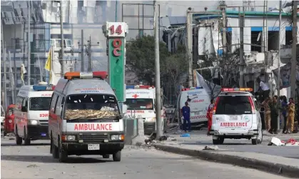  ?? Photograph: Hassan Ali Elmi/AFP/Getty Images ?? Security personnel and ambulances near the blast site after a car bombing targeted the education ministry in Mogadishu, Somalia, on Saturday, leaving at least 100 dead.