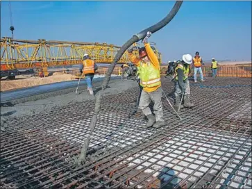  ?? California High-Speed Rail Authority ?? CONSTRUCTI­ON on the bullet train continues as concrete is poured over rebar for an overcrossi­ng in Madera County. The statewide high-speed rail project has been beset by cost overruns, delays and mismanagem­ent.