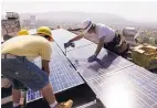  ?? ASSOCIATED PRESS ?? Installers from California Green Design install solar electrical panels on the roof of a home in Glendale, Calif.