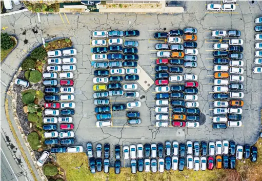  ??  ?? Unsold and unneeded vehicles crowd the lot at Kelly Nissan in the Boston suburb of Lynnfield, Massachuse­tts, April 8. Traffic Jammed Photograph by Michael Prince