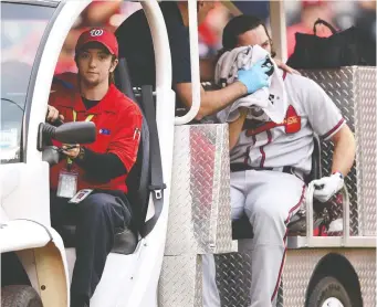  ?? MITCHELL LAYTON/GETTY IMAGES ?? Medical staff takes Charlie Culberson of the Atlanta Braves off the field after Culberson was hit in the face by a pitch during a game against the Nationals Saturday in Washington.