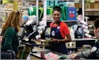  ?? AP PHOTO BY STEVEN SENNE ?? In this May 8, photo, Nadine Vixama, who emigrated from Haiti eight years ago, works as a cashier at a Whole Foods in Cambridge, Mass.