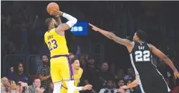  ?? (Gary A. Vasquez/USA Today Sports) ?? LOS ANGELES Lakers forward LeBron James shoots against San Antonio Spurs forward Rudy Gay during overtime at Staples Center.