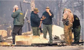  ?? NOAH BERGER/ASSOCIATED PRESS ?? Sheriff’s deputies recover the remains of Camp Fire victims in Paradise, Calif., on Saturday. Most of the town was destroyed, and at least 23 people were killed, with many more missing.