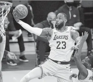  ?? Mark J. Terrill Associated Press ?? LeBRON JAMES, soaring by Miami’s Kendrick Nunn, almost had a triple-double with 19 points, nine rebounds and nine assists, but he had just four points in the second half.