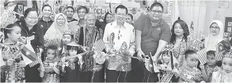  ??  ?? SIMBOLIK: Lee (tengah) dan Ikhwan (kanan) bersama yang lain memotong reben sempena sambutan Hari Malaysia di Tabika Perpaduan Desa Senadin semalam.