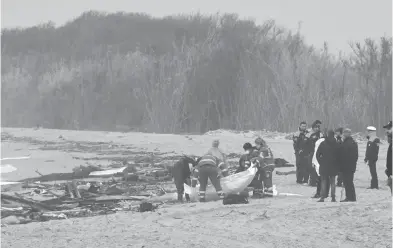  ?? AFP ?? Rescatista­s recuperan un cuerpo entre la embarcació­n destrozada en Steccato di Cutro