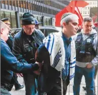  ??  ?? 維權人士21日在芝加­哥遊行支持移民，警方逮捕一名不服從命­令的猶太教士（上圖），並送上警車（下圖）。 (歐新社)