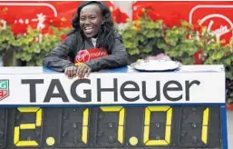  ?? ADRIAN DENNIS/AFP/GETTY IMAGES ?? Kenya’s Mary Keitany celebrates with her official time as she poses after the Women's elite race at the London marathon on Sunday. She broke a 12-year-old record.