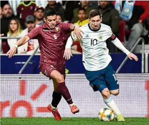  ?? — AFP ?? Still quick: Argentina’s Lionel Messi (right) dribbling past Venezuela’s Yordan Osorio during an internatio­nal friendly match at the Wanda Metropolit­ano Stadium on Friday.