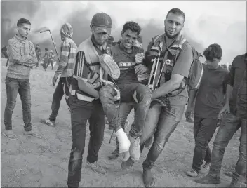  ?? AP PHOTO ?? Palestinia­n medics evacuate a wounded protester at the Gaza Strip’s border with Israel, Friday.