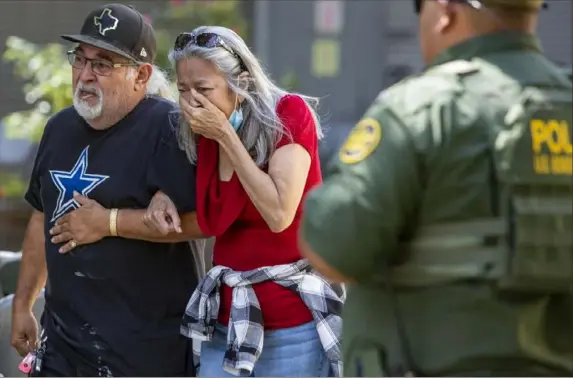  ?? William Luther/The San Antonio Express-News via AP ?? A woman cries as she leaves the Uvalde Civic Center on Tuesday in Uvalde, Texas. An 18-year-old gunman opened fire at Robb Elementart­y School, killing 19 children and three adults. It was the deadliest U.S. shooting at a grade school since Sandy Hook in 2012.