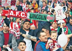  ??  ?? Loud and proud: Lincoln City fans make the most of their day at the Emirates