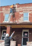  ??  ?? Ephraim Laidley Jr., below, directs restoratio­n as workers prep a building on East Livingston Avenue to be painted earlier this month.