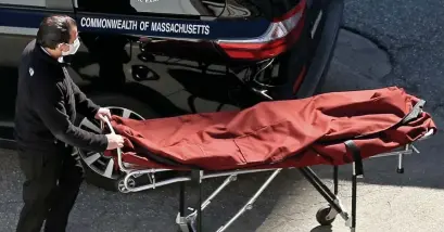  ?? MATT sTONe / HeRALd sTAFF FILe ?? PLENTY OF BUSINESS: A worker pushes an empty mortuary stretcher at the Office of the Chief Medical Examiner last April.