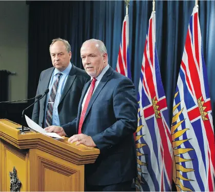  ?? CHAD HIPOLITO/THE CANADIAN PRESS ?? Green party Leader Andrew Weaver and Premier John Horgan speak to media following the announceme­nt of legislatio­n banning union and corporate donations to political parties during a press conference in Victoria on Monday.