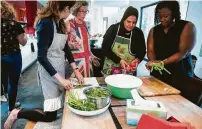  ??  ?? Michelle Jennings, from left, Sophy Ashworth, Wafdia Ibrahim and Valerie Cramer prepare vegetables during a dinner party featuring foods from Syria at Ashworth’s West University Place home. Ibrahim fled civil war in her native Syria and offers private cooking classes for Houstonian­s.