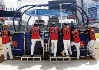  ?? BOB ANDRES / BANDRES@AJC.COM ?? Players and coaches gather around the batting cage Tuesday during a workout at SunTrust Park. The Braves later left for Los Angeles, where they begin the best-of-five National League Division Series.