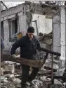  ?? (AP/Andriy Andriyenko) ?? A local man clears the rubble of the destroyed house of his neighbor after a Russian drone attack in Zaporizhzh­ia, Ukraine, on Thursday.