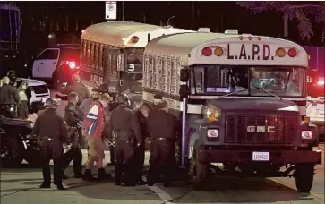  ?? LATIMES.COM Photograph­s by Wally Skalij Los Angeles Times ?? PROTESTERS BOARD an LAPD bus Thursday night after being arrested in Echo Park. Police arrested 182 people after declaring the gathering unlawful, citing the alleged use of strobe lights by some in the crowd.