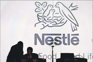  ?? AP FILE PHOTO ?? Nestle’s directors speak in front of the Nestle logo during the general meeting of the world’s biggest food and beverage company, Nestle Group, in Lausanne, Switzerlan­d, in April.