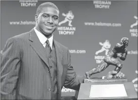  ?? Stephen Chernin/Getty Images North America/TNS ?? Running back Reggie Bush #5 of the USC Trojans poses with the 2005 Heisman trophy after winning the award at the 71st Annual Heisman Ceremony on Dec. 10, 2005, in New York City.