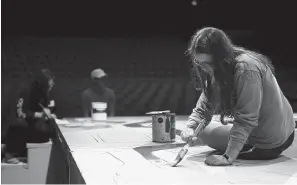  ?? Staff photo by Hunt Mercier ?? ■ Chloe Pate paints on stage, preparing for the Texas High School production of "Metamorpho­ses." The Texas High School Tiger Theatre Company will perform the play as their first of the year on Thursday, Oct. 18 through Sunday, Oct. 21.