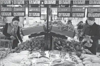  ?? HU GUOLIN / FOR CHINA DAILY ?? Customers shop for vegetables in a supermarke­t in Jiujiang, Jiangxi province, on Friday.