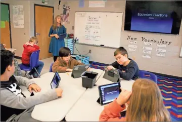  ?? Daniel Bell ?? Courtney Hales, a fifth grade math teacher at Tolbert Elementary School, teaches fractions on Monday using iPads and an Apple TV.