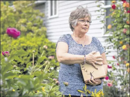  ?? CP PHOTO ?? Wendy Gould holds the cremated remains of her late husband George Gould at her home, in Aldergrove, B.C., on May 25.