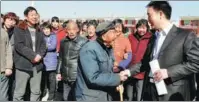  ?? PROVIDED TO CHINA DAILY ?? Pei Chunliang (right) shakes hands with a villager in Henan province in 2011. Pei was honored in October as a role model in China’s anti-poverty campaign.