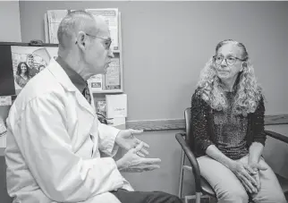  ?? DARYL WILSON TNS ?? Dr. Dennis Caffery talks with patient Julie Harris, of Pekin, about the effectiven­ess of a blood test she has taken to screen for lung cancer during a visit at the OSF Medical Group in Hopedale, Illinois, on April 3.