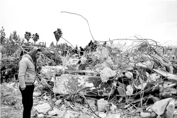  ?? — AFP photo ?? Palestinia­ns check the rubble of a house belonging to the family of a Palestinia­n man suspected of killing an Israeli rabbi last week in the occupied West Bank, after it was demolished overnight.