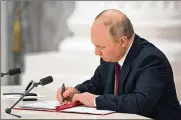  ?? ASSOCIATED PRESS ?? Russian President Vladimir Putin signs a document recognizin­g the independen­ce of separatist regions in eastern Ukraine.