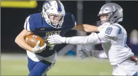  ?? (Special to NWA Democrat-Gazette/David Beach) ?? Ty Durham (left) of Bentonvill­e West throws a stiff arm against a Fort Smith Southside player Friday at Wolverine Stadium in Bentonvill­e.