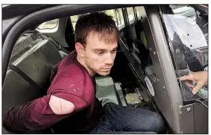  ?? AP/Metro Nashville Police Department ?? Travis Reinking sits in a police car after his arrest Monday in Nashville, Tenn.