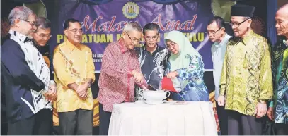  ??  ?? RASMI: Talib menggaul tepung sagu sambil dibancuh dengan air panas untuk membuat Na’aw (linut atau ambuyat) sebagai simbolik perasmian Malam Amal Persatuan Melanau Bintulu sambil disaksikan oleh Shamsuddin (tengah), Mohidin, Barry, Kadier (kiri),...