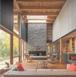  ?? NIC LEHOUX PHOTOS ?? The blue granite double-height, double-sided fireplace, the centrepiec­e of the living space under a skylight, opens to the living area, the master bedroom and first-floor patio.