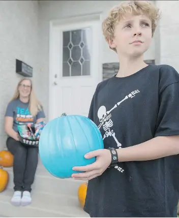  ?? LIAM RICHARDS ?? Katriona Mitchell and her son James, who has a severe allergy, were getting ready for Halloween with a teal pumpkin and allergy friendly Halloween treats in front of their home Friday.