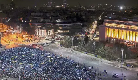  ??  ?? Speaking up: Romanians lighting up blue pieces of paper and pieces of yellow star shaped fabric to form the EU flag during a protest against the government in Bucharest. — Reuters