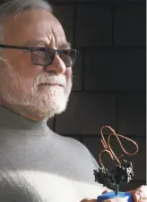  ?? Lea Suzuki / The Chronicle ?? Peter Walter, a biochemist at UCSF and one of this year’s recipients of the Breakthrou­gh Prize, holds a model of his promising molecule binding to an unfolded protein. The molecule may one day be used to treat dozens of conditions.