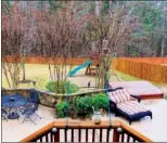  ??  ?? A cascading waterfall and a koi pond add to the oasislike backyard. The privacy-fenced space also features a deck, a rock-walled patio, a   agstone   re-pit area and a children’s play set.