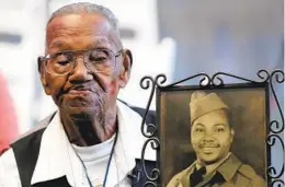  ?? GERALD HERBERT AP FILE ?? World War II veteran Lawrence Brooks holds a photo of him taken in 1943, as he celebrates his 110th birthday at the National World War II Museum in 2019.