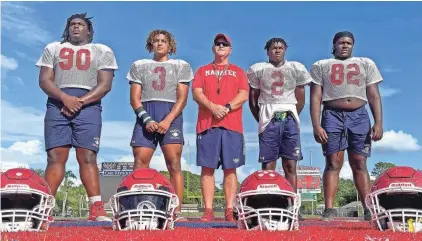  ?? THOMAS BENDER/HERALD-TRIBUNE ?? The Manatee defense has been chiefly responsibl­e for the team's undefeated start. Defensive coordinato­r Travis Baity with (left to right) Tyreek Robinson, Tez McDowell, Chris Johnson and Ean Johnson-Kelley.