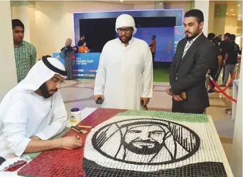  ?? Abdul Rahman/Gulf News ?? Visitors look at the ceramic painting of Shaikh Zayed Bin Sultan Al Nahyan by Emirati artist Abdullah Sulaiman at the Korea Festival at National Theatre in Abu Dhabi yesterday.