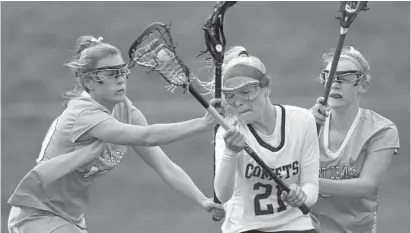  ?? STEVE RUARK/BALTIMORE SUN MEDIA GROUP ?? Catonsvill­e’s Kolby Weedon, middle, moves the ball against Mount de Sales’ Sloane Skalstad, left, and Libby Rehkemper in the first half. Weedon led the Comets with three goals while her sister Amber finished with 12 saves.