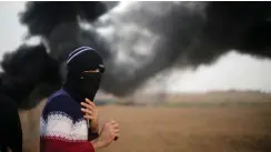  ??  ?? A MASKED Palestinia­n looks on during clashes with Israeli soldiers at a protest near Gaza’s border with Israel on Friday.