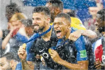  ?? AP PHOTO BY NATACHA PISARENKO ?? France’s Kylian Mbappe, right, and teammate Olivier Giroud celebrate Monday after the final match between France and Croatia at the 2018 soccer World Cup in the Luzhniki Stadium in Moscow, Russia.