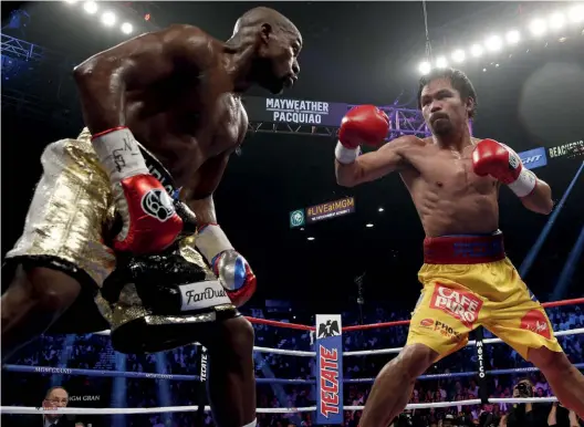  ?? Photo: JOHN GURZINSKI/AFP/GETTY IMAGES ?? HUGE EVENT: Mayweather stands off as Pacquiao attacks