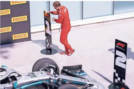  ?? FOTO: AP ?? Selbstjust­iz: Sebastian Vettel baut die Platzierun­gsschilder im Zielraum um.